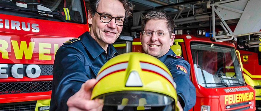 Zwei Feuerwehrleute und ein Helm