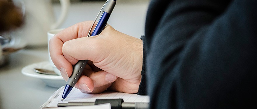 Hand, die einen Kugelschreiber hält