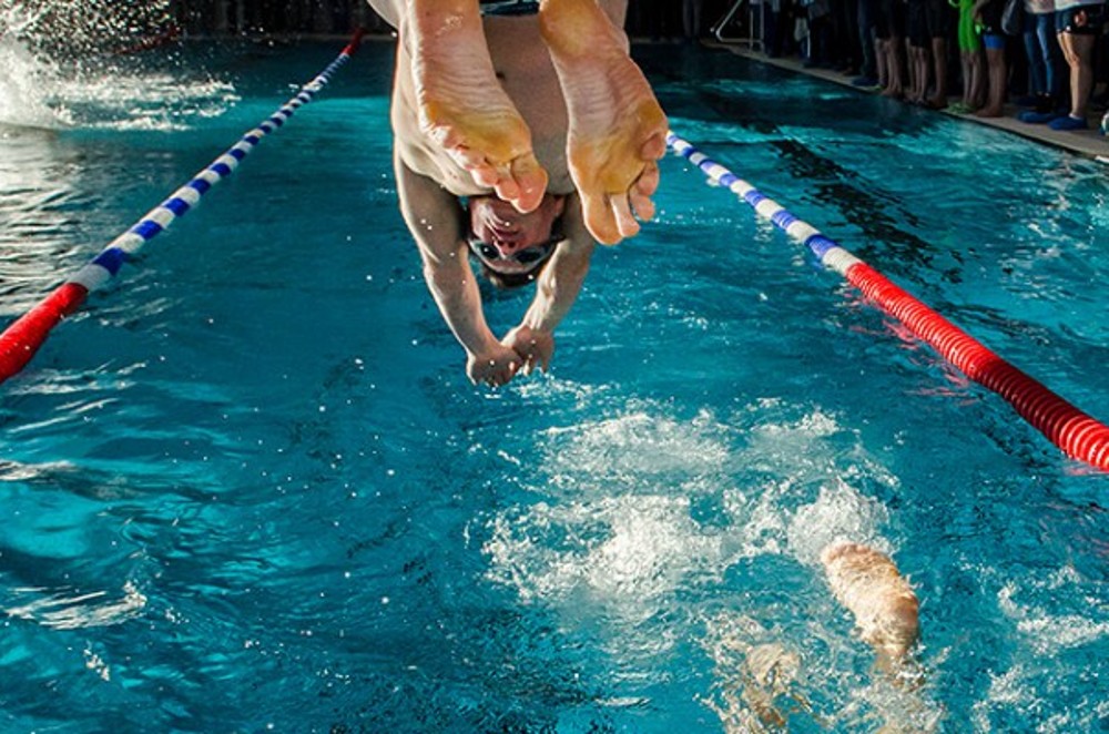 Schwimmer springt ins Becken.