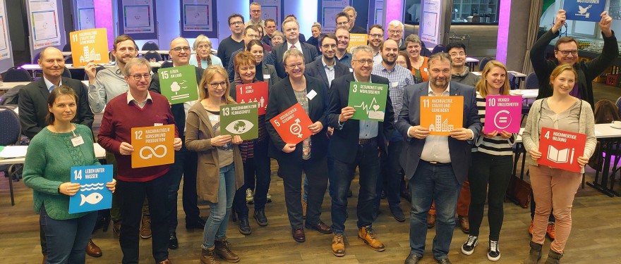 Menschen halten bunte Tafeln in den Händen.