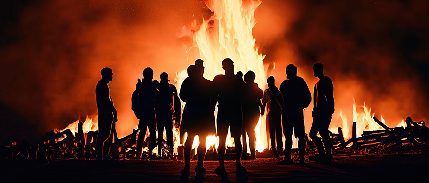 Menschen stehen bei Dunkelheit vor einem Osterfeuer