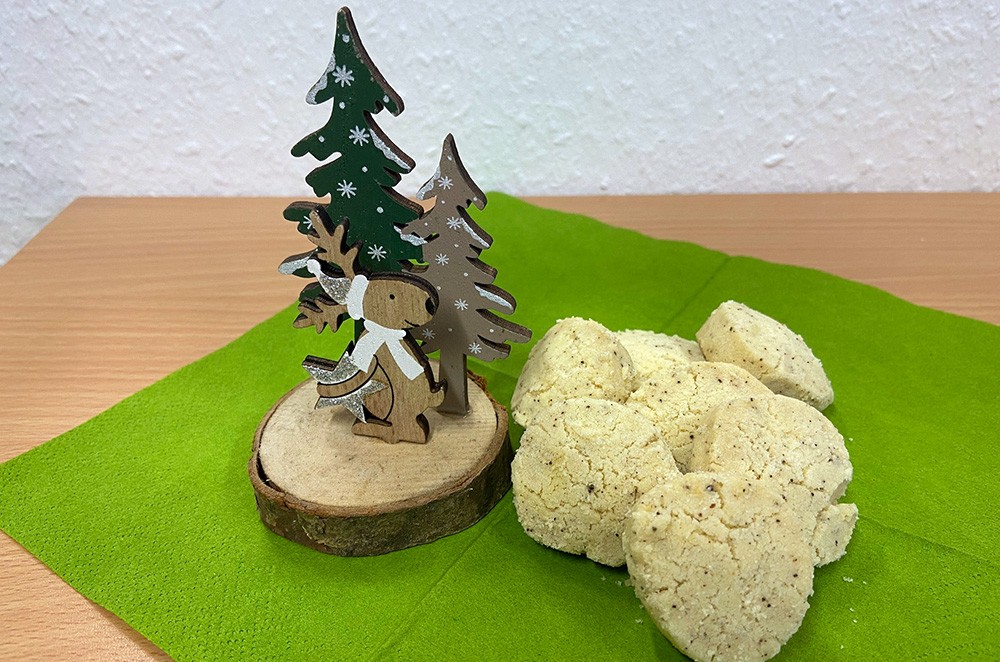 Heidesandkekse und Weihnachtsdekoration auf einem grünen Tuch
